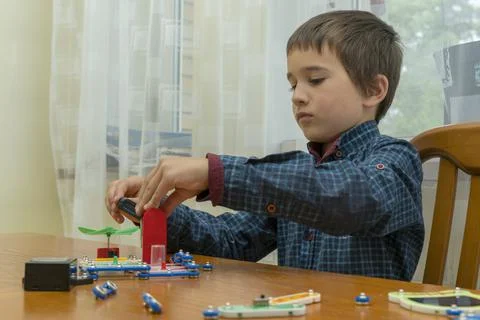The boy playing an electric constructor. The child is played by intellectual Stock Photos