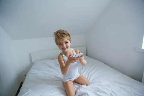 Boy playing on electronic gadget tablet in his bedroom. Social problem of Stock Photos