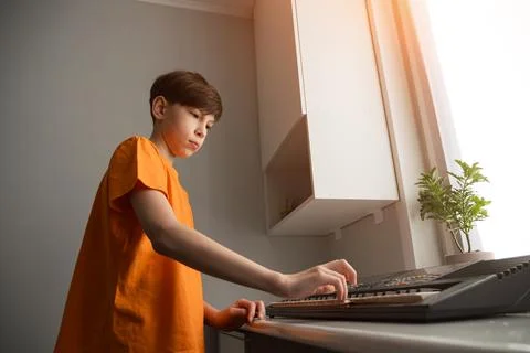 Boy playing electronic keyboard learning to play music Stock Photos
