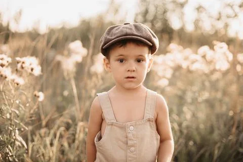 A boy is playing on a farm or ranch field, resting. Portrait of a child boy in a Stock Photos