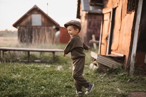 A boy is playing on a farm or ranch field, resting. Portrait of a little boy in Stock Photos
