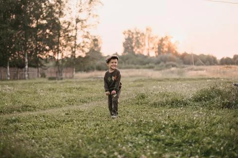 A boy is playing on a farm or ranch field, resting. Portrait of a little boy in Stock Photos