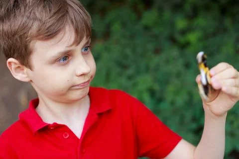 Boy playing with fidget spinner, close up. Childhood, gadgets, e Stock Photos