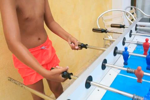 Boy playing  foosball in a pool Stock Photos