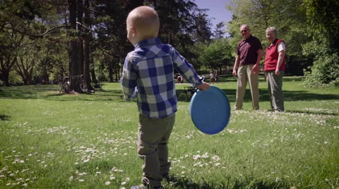 Boy playing frisbee in park Stock Footage 64452997