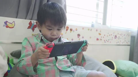 Boy Playing game on bed 스톡 동영상 192444261