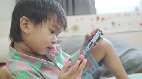 Boy Playing game on bed 스톡 동영상 192444272