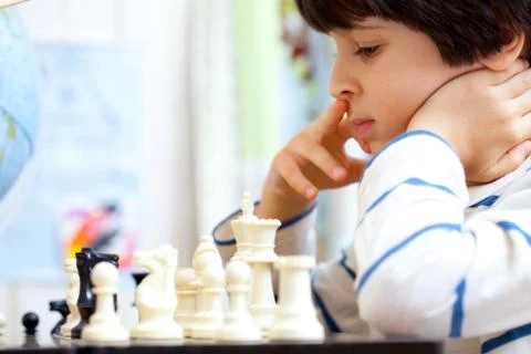 Boy playing a game of chess Foto stock