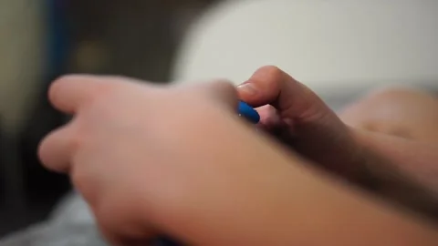 Boy playing game console sitting on bed. hands with gamepad close up Stock Footage 297553147