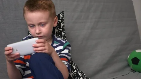 Boy playing game on mobile Stock Footage 98258610