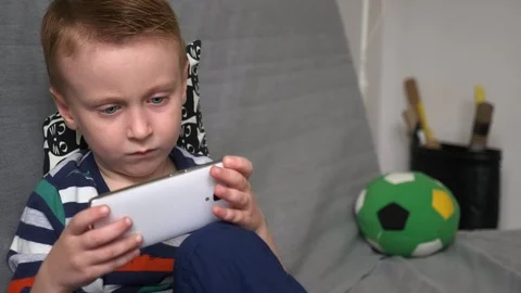 Boy playing game on mobile Stock Footage 98259551