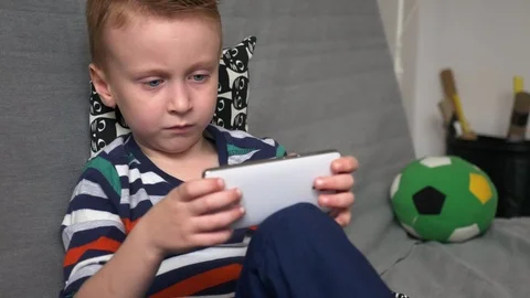 Boy playing game on mobile Stock Footage 98261498