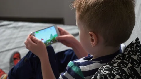 Boy playing game on mobile Video stock 98261883
