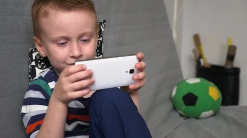 Boy playing game on mobile Stock Footage 98263617