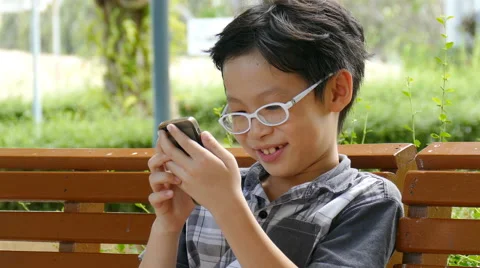Boy playing game on smart phone Stock Footage 64112274