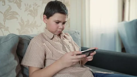 Boy playing game on smartphone Stock Footage 241438138