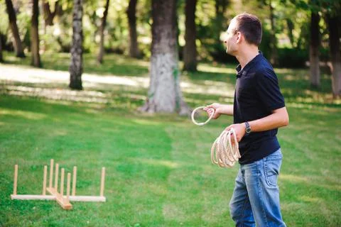 Boy playing a game throwing rings outdoors in summer park Stock Photos