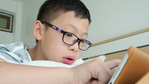 Boy playing games on digital tablet computer Stock Footage 89267780