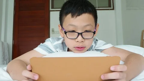 Boy playing games on digital tablet computer Stock Footage 89319508