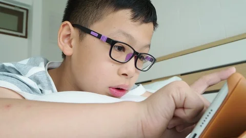 Boy playing games on digital tablet computer Stock Footage 89319835