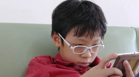 Boy playing games on phone Stock Footage 64411185