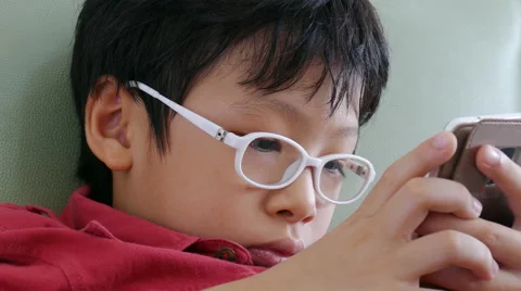 Boy playing games on phone Stock Footage 64412383