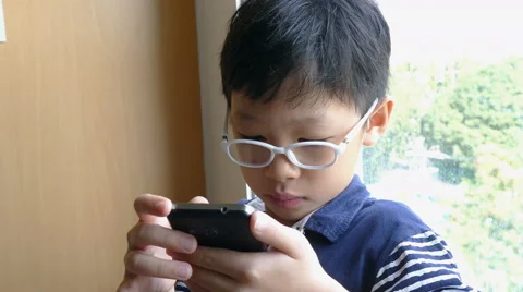 Boy playing games on smart phone Stock Footage 63581894