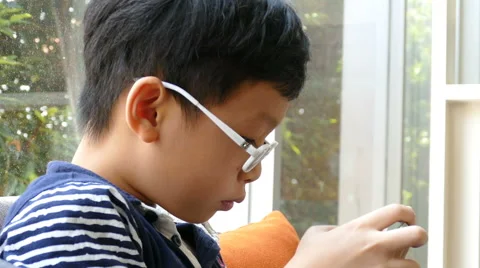 Boy playing games on smart phone Stock Footage 63654166