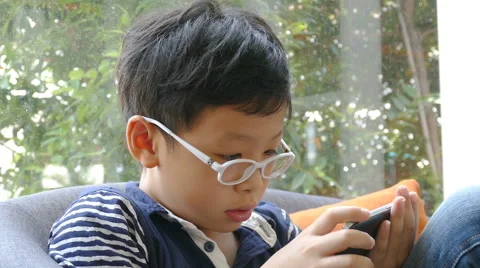 Boy playing games on smart phone Stock Footage 63654386