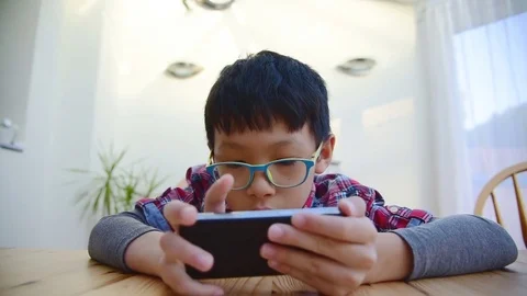 Boy playing games on smart phone Stock Footage 69895833