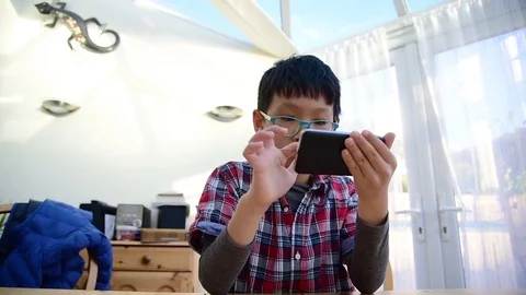 Boy playing games on smart phone Stock Footage 69896012