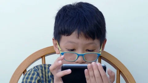 Boy playing games on smart phone Stock Footage 70168137