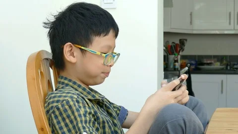 Boy playing games on smart phone Stock Footage 70184583