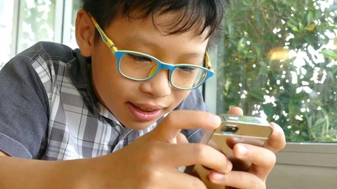 Boy playing games on smart phone Stock Footage 76452249
