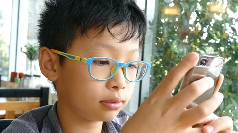 Boy playing games on smart phone Stock Footage 76452660