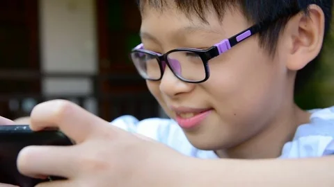 Boy playing games on smart phone Stock Footage 83148783