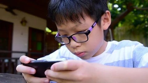 Boy playing games on smart phone Stock Footage 83148988