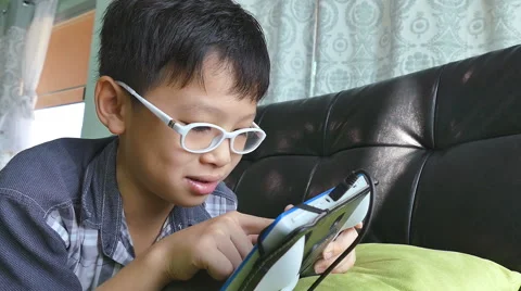Boy playing games on the tablet computer Stock Footage 55197933