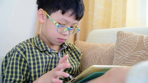 Boy playing games on tablet computer Stock Footage 74990010