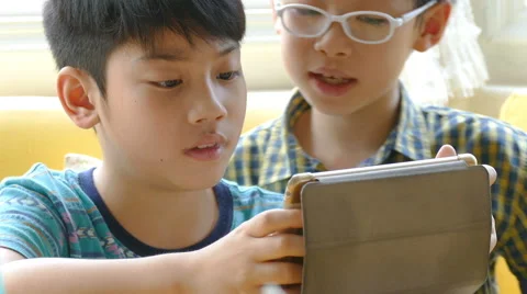 Boy playing games on a touchscreen tablet Stock Footage 62610859