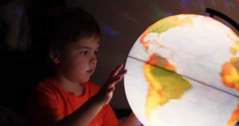 Boy Playing With Globe at Night. Child Sits on Bed in Evening Light Dreamin.. Stock-Footage 318498136