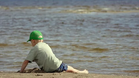 Boy Playing With Golden Sand by the Baltic Sea Stock Footage 345551022