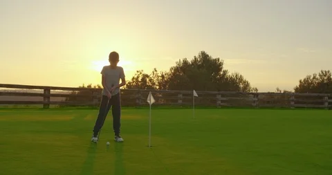 Boy playing golf with at sunset. Stock Footage 122121641