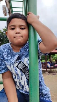 A boy playing on a green iron pole Stock Photos