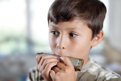 Boy playing harmonica Stock Photos