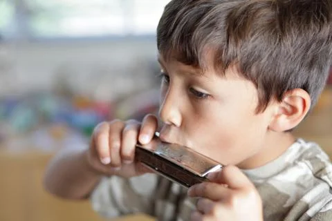 Boy playing with harmonica Stock Photos
