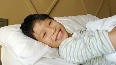 Boy playing hide and seek on the bed ,slow motion Stock Footage 61683457