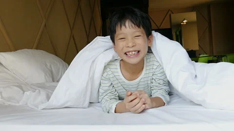 Boy playing hide and seek on the bed ,slow motion Stock Footage 61683618