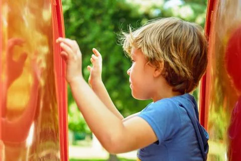 The boy is playing with his reflection Stock Photos