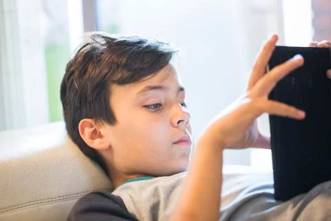 Boy playing with his tablet Stock Photos